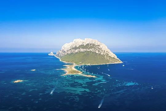 View from above, stunning aerial view of the beautiful Tavolara Island with its beach bathed by a turquoise clear sea. Tavolara is a small island off the northeast coast of Sardinia, Italy.